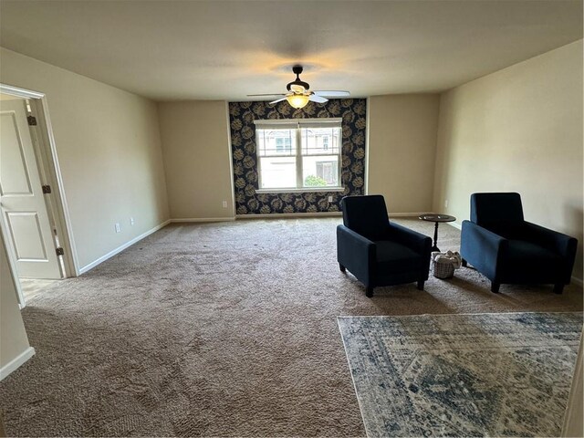 living area featuring ceiling fan and carpet