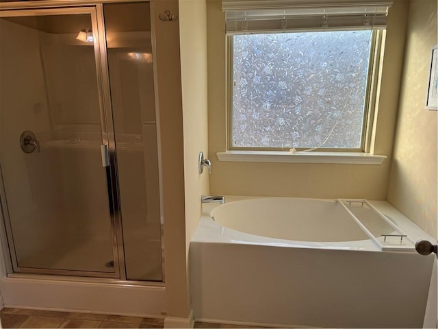 bathroom with plenty of natural light and separate shower and tub