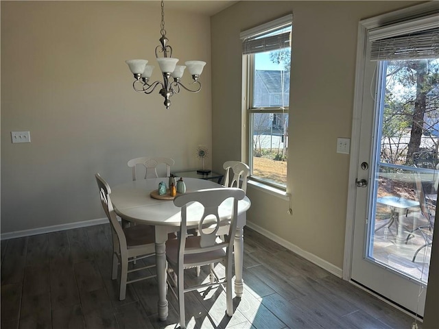 dining space with dark hardwood / wood-style floors and an inviting chandelier