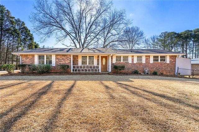 ranch-style home with a front yard and covered porch