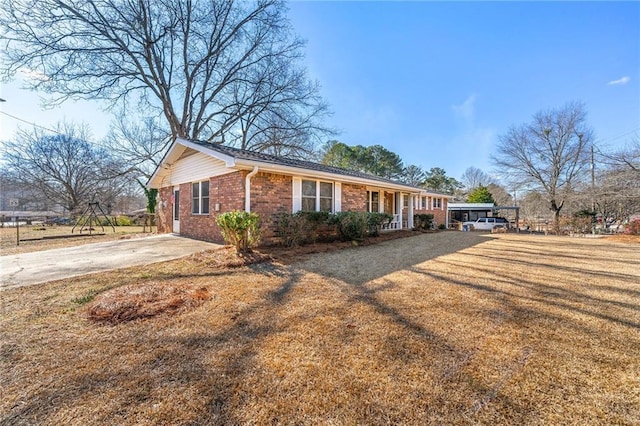 ranch-style house with a front yard and covered porch