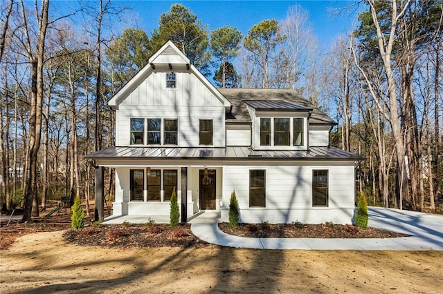 modern farmhouse style home with a standing seam roof, metal roof, covered porch, and board and batten siding