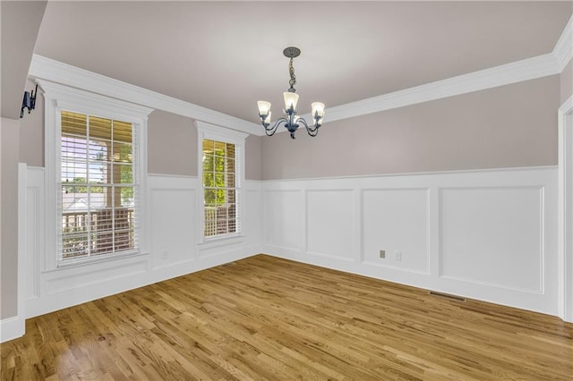 4424 Longmead Rd, Flowery Branch, GA 30542 - unfurnished dining area featuring a chandelier, light wood-type flooring, a decorative wall, crown molding, and a wainscoted wall