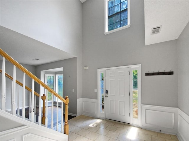 entryway featuring light tile patterned floors and a high ceiling