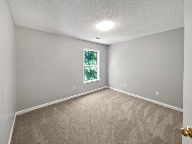 unfurnished room featuring carpet flooring and a textured ceiling