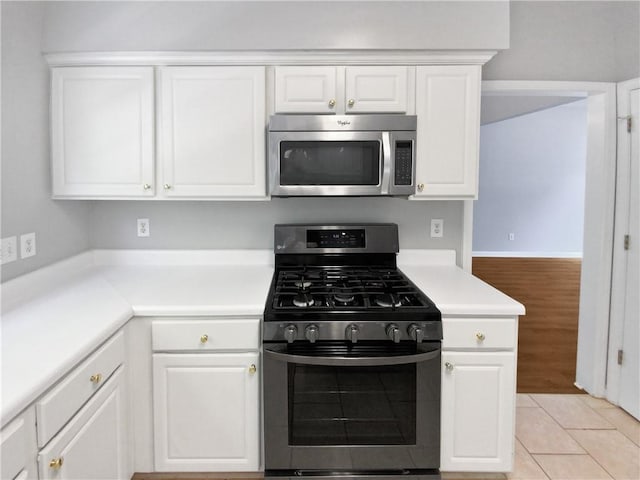 kitchen with white cabinets, light tile patterned floors, and stainless steel appliances