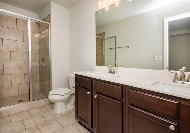 bathroom featuring tile patterned floors, an enclosed shower, double vanity, and toilet