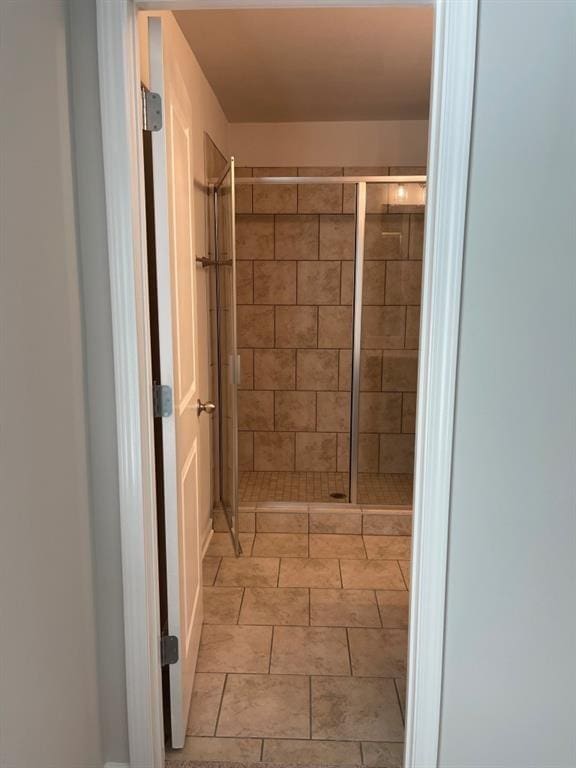 bathroom featuring tile patterned flooring and an enclosed shower