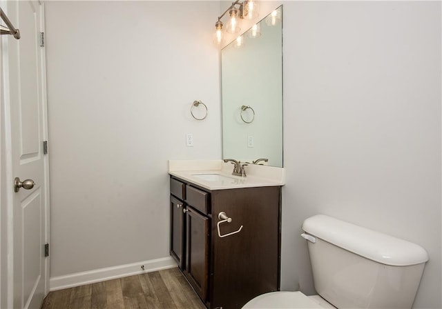 bathroom featuring wood-type flooring, toilet, and vanity