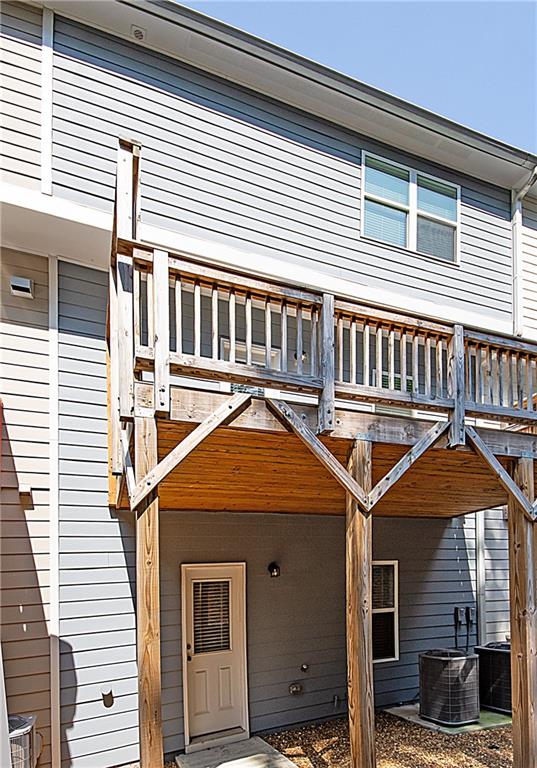 back of house featuring central air condition unit and a balcony