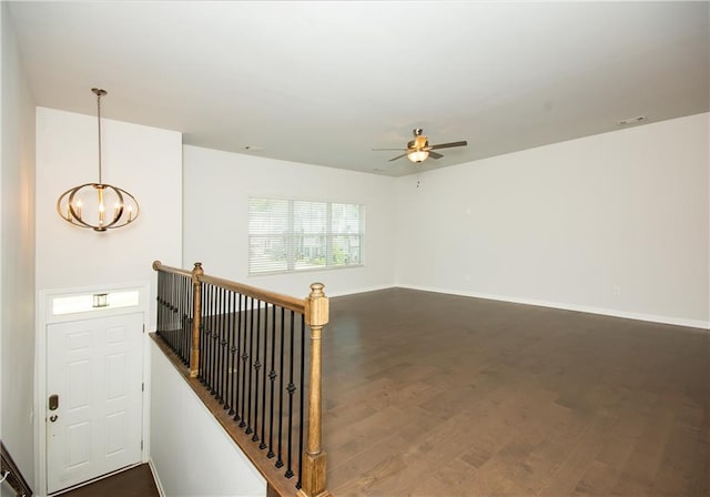 unfurnished room featuring ceiling fan with notable chandelier and hardwood / wood-style floors