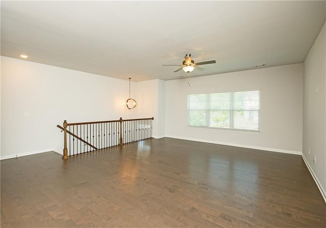 spare room with ceiling fan and dark wood-type flooring