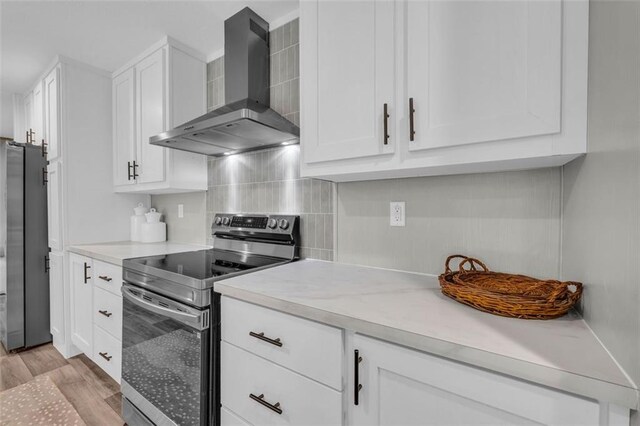 551 Fern Valley Trl, Clarkesville, GA 30523 - kitchen featuring wall chimney exhaust hood, appliances with stainless steel finishes, white cabinetry, light countertops, and light wood-style floors