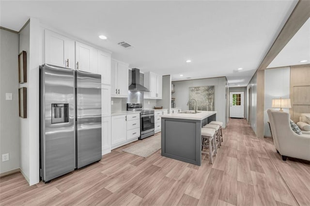 551 Fern Valley Trl, Clarkesville, GA 30523 - kitchen featuring appliances with stainless steel finishes, wall chimney exhaust hood, a sink, white cabinets, and light wood-style flooring