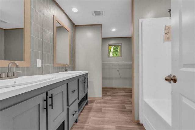 551 Fern Valley Trl, Clarkesville, GA 30523 - bathroom with double vanity, wood finished floors, tile walls, decorative backsplash, and recessed lighting