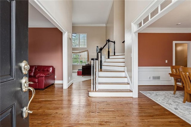 foyer entrance featuring hardwood / wood-style floors and crown molding