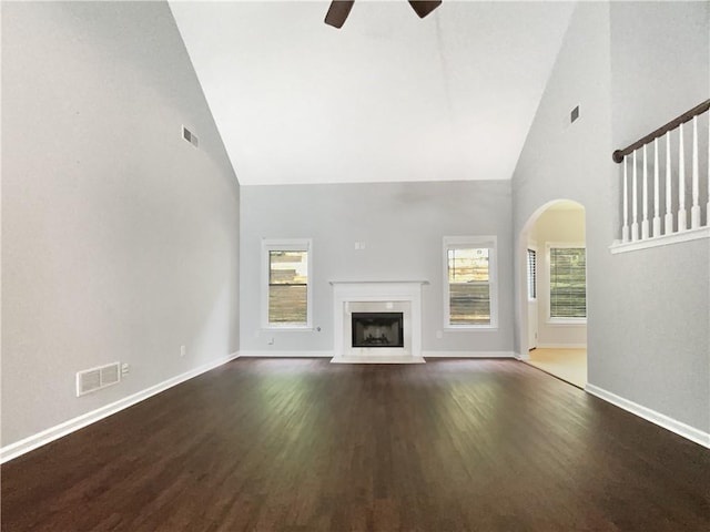 200 Pine Trl, Dallas, GA 30157 - unfurnished living room featuring high vaulted ceiling, a ceiling fan, wood finished floors, arched walkways, and a fireplace with flush hearth