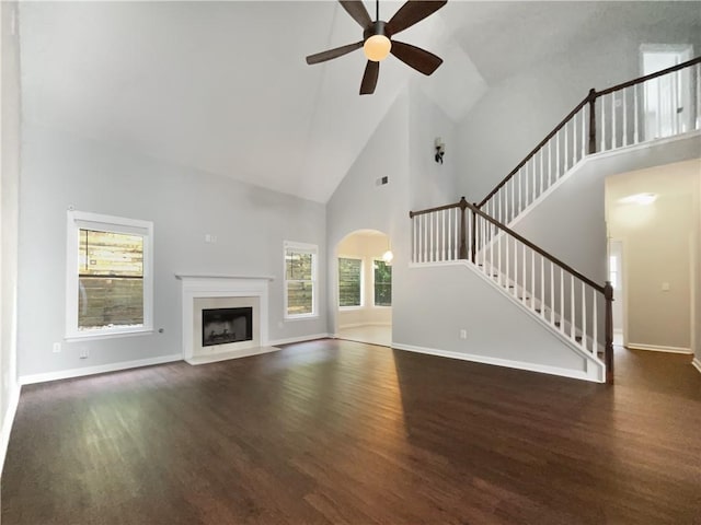 200 Pine Trl, Dallas, GA 30157 - unfurnished living room with high vaulted ceiling, wood finished floors, a ceiling fan, arched walkways, and stairs