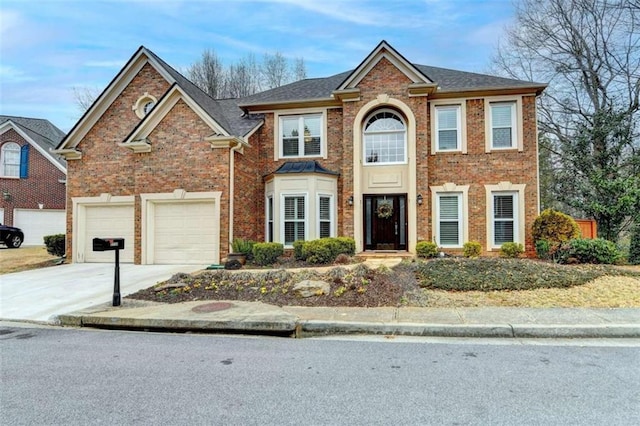 colonial-style house with driveway, a garage, and brick siding