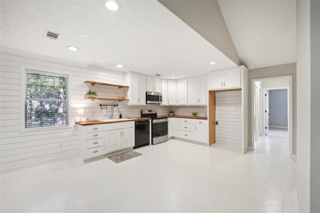 kitchen with white cabinetry, decorative backsplash, butcher block counters, lofted ceiling, and stainless steel appliances