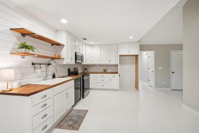 kitchen with white cabinets, appliances with stainless steel finishes, tasteful backsplash, and sink