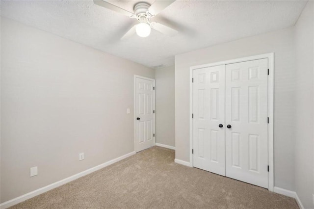 unfurnished bedroom with ceiling fan, light colored carpet, and a closet