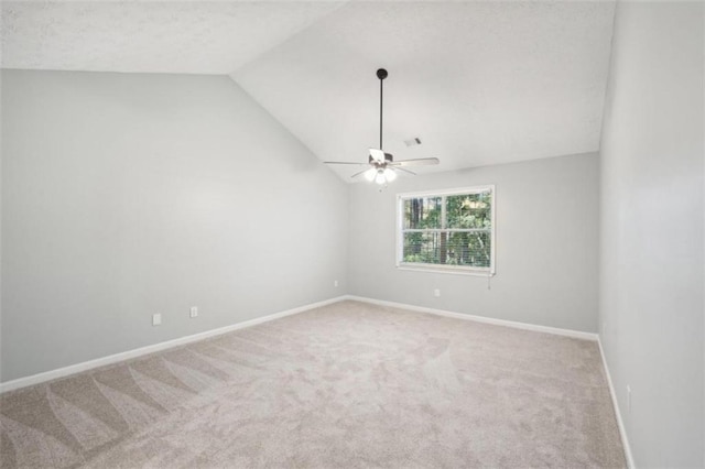 carpeted spare room with ceiling fan and lofted ceiling