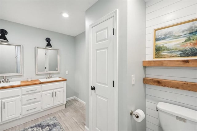 bathroom with hardwood / wood-style flooring, toilet, and vanity