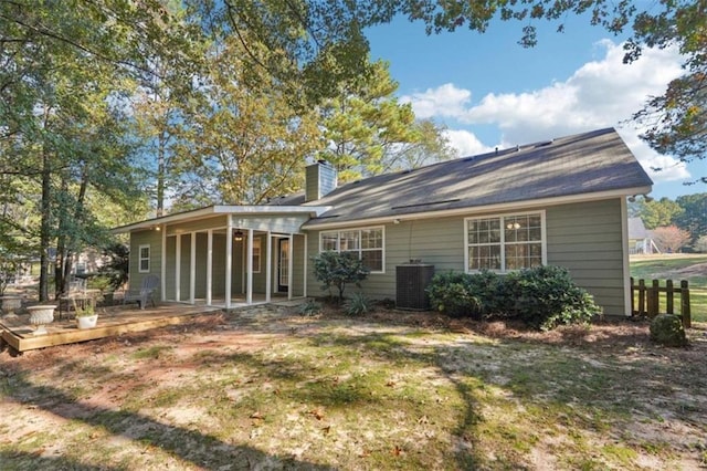 rear view of house featuring cooling unit, a wooden deck, and a yard