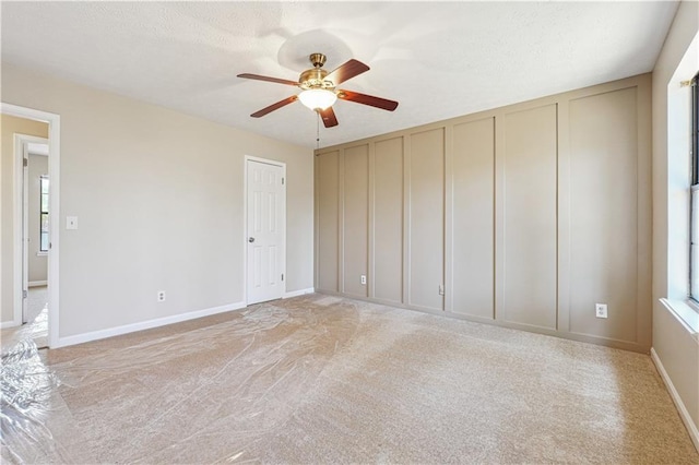 spare room featuring light colored carpet and ceiling fan