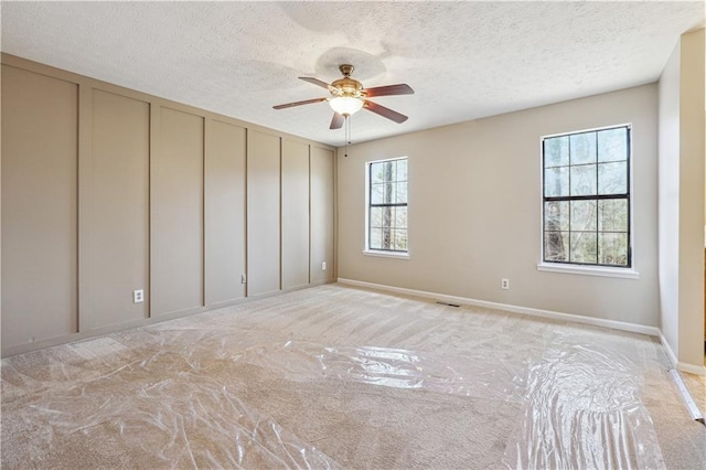 empty room featuring ceiling fan and a textured ceiling