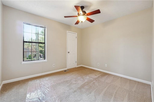 unfurnished room with ceiling fan and light carpet