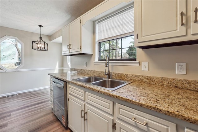 kitchen with sink, white cabinetry, dishwasher, pendant lighting, and light hardwood / wood-style floors