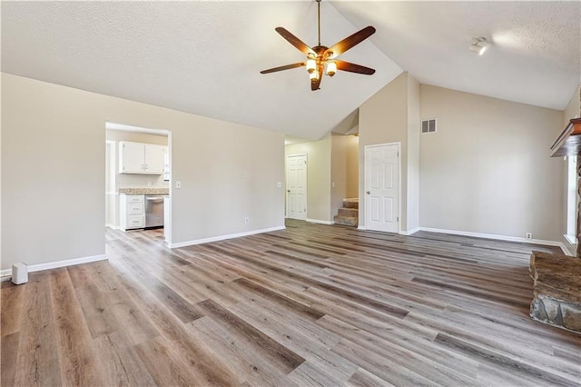 unfurnished living room with ceiling fan, high vaulted ceiling, light hardwood / wood-style floors, and a textured ceiling