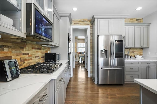 1165 Laurel Pl SE, Smyrna, GA 30080 - kitchen with appliances with stainless steel finishes, gray cabinetry, backsplash, glass insert cabinets, and dark wood-style flooring