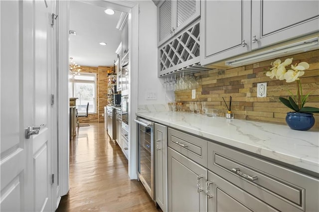 1165 Laurel Pl SE, Smyrna, GA 30080 - kitchen with beverage cooler, light wood-type flooring, decorative backsplash, light stone counters, and recessed lighting
