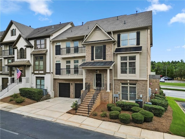 1165 Laurel Pl SE, Smyrna, GA 30080 - townhome / multi-family property with brick siding, driveway, an attached garage, a balcony, and a standing seam roof