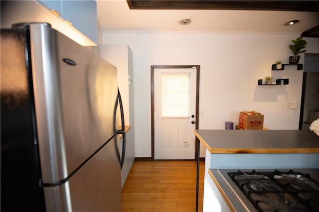 kitchen with gas cooktop, stainless steel fridge, and light wood-type flooring