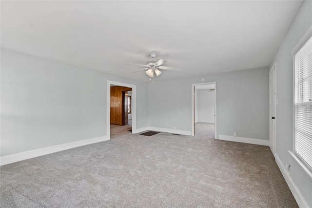 empty room featuring carpet, baseboards, and ceiling fan