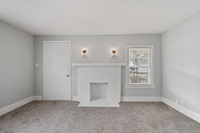 unfurnished living room featuring a brick fireplace, carpet flooring, and baseboards