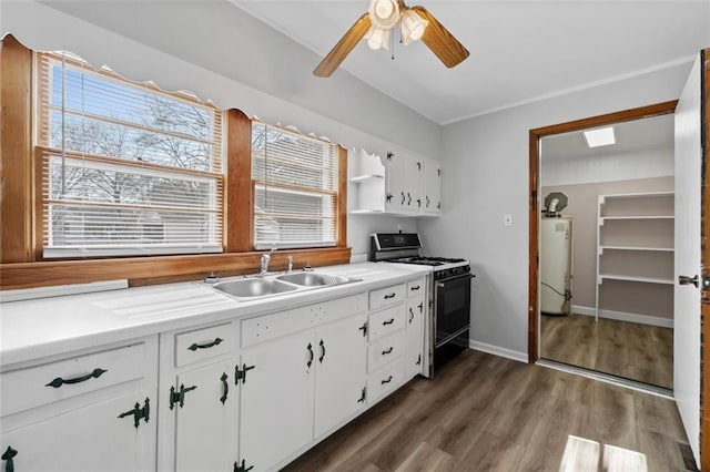 kitchen featuring a sink, white cabinets, light countertops, gas range oven, and dark wood finished floors