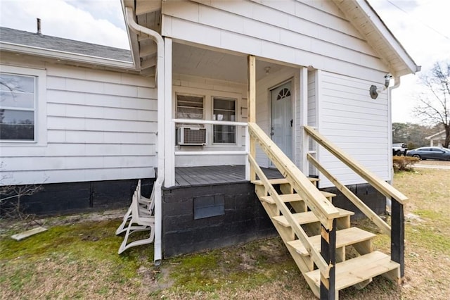 doorway to property with a shingled roof and cooling unit