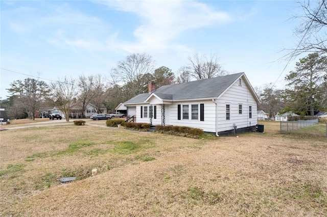 view of front facade featuring a chimney, fence, and a front yard