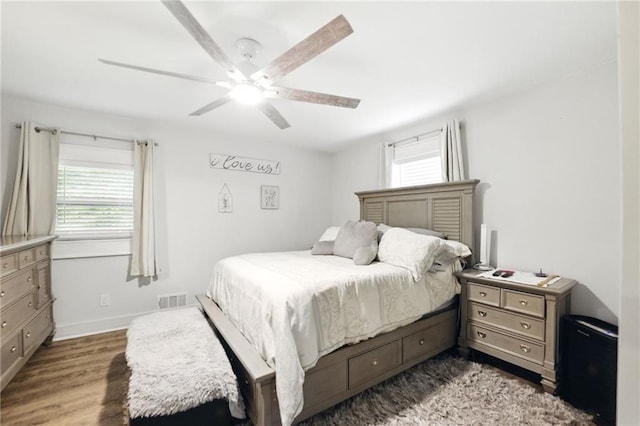 bedroom with wood finished floors, baseboards, and ceiling fan