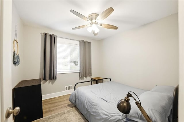 bedroom featuring wood finished floors, baseboards, and a ceiling fan