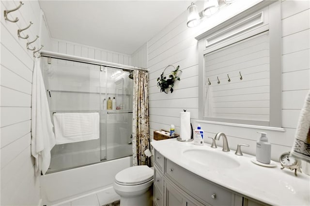 bathroom featuring bath / shower combo with glass door, toilet, vanity, and wood walls