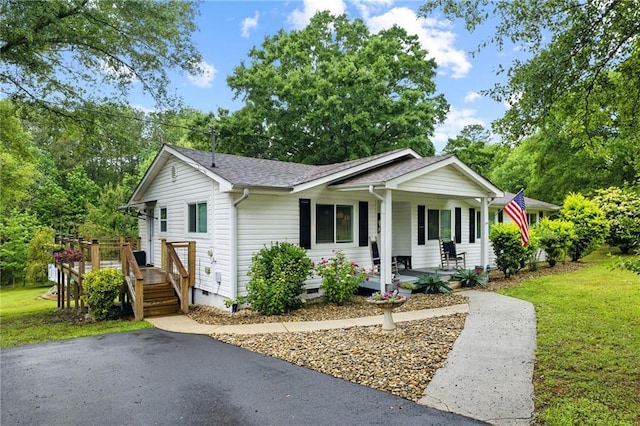 ranch-style house with crawl space, a porch, a front lawn, and roof with shingles