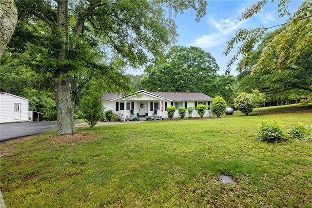 ranch-style home with covered porch and a front yard