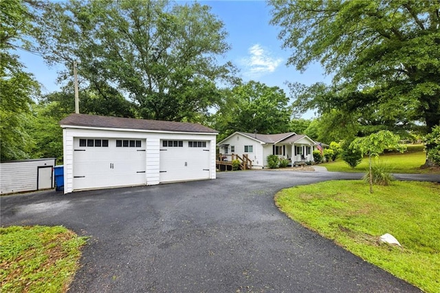 view of front facade featuring an outdoor structure and a detached garage