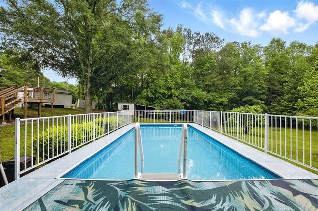 view of swimming pool with view of wooded area
